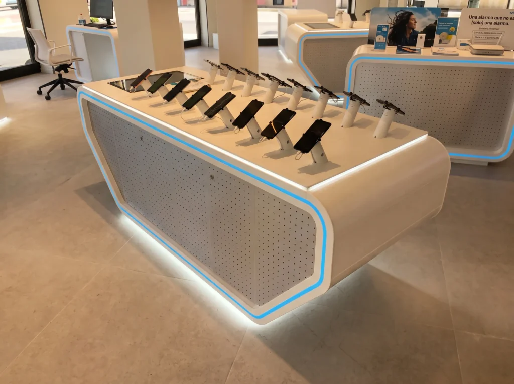 Mobiliario comercial a medida en solid surface blanco con luz LED azul para una tienda Movistar de Valencia