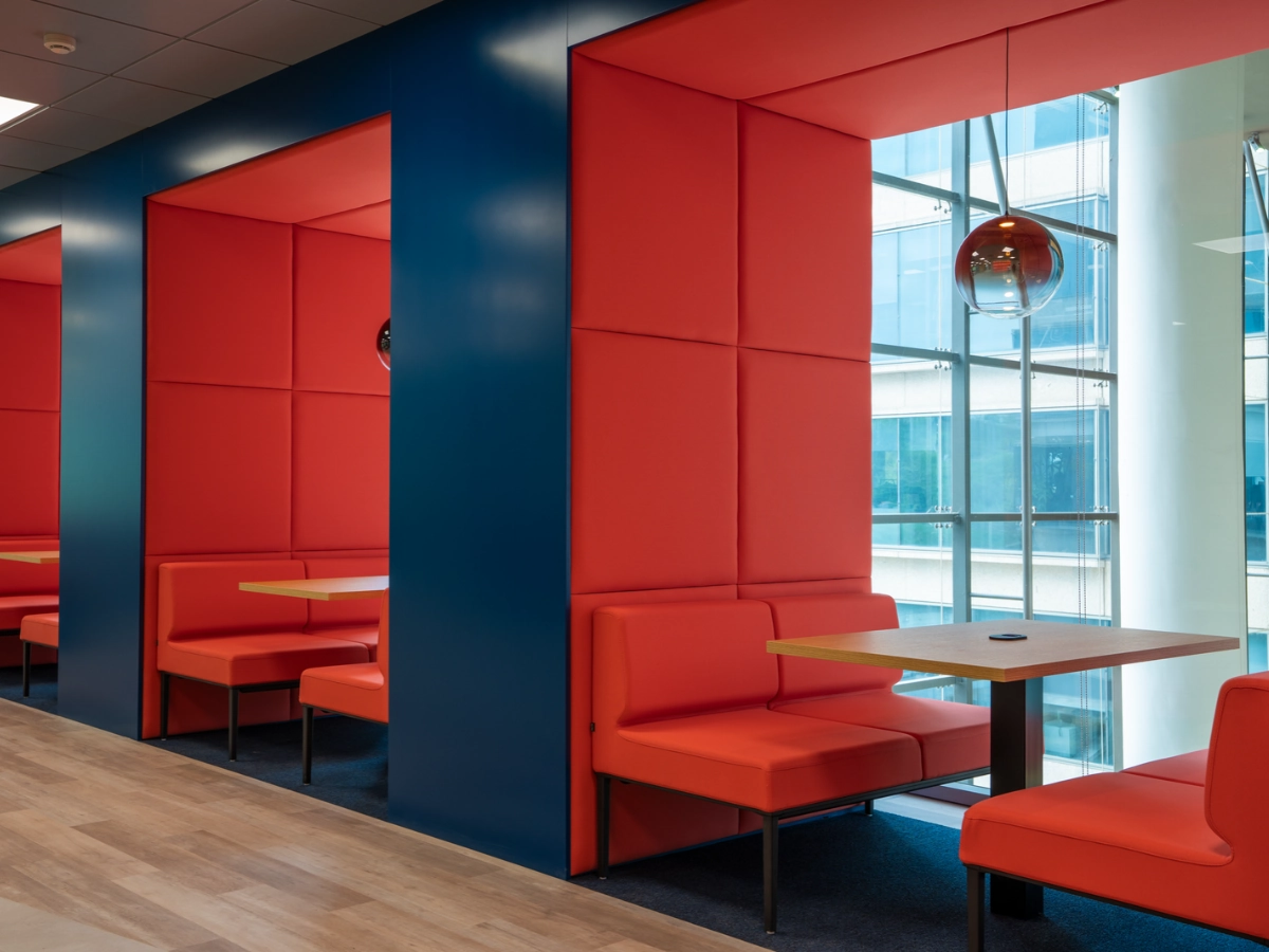 Cabinas tapizadas con mesa de madera en las oficinas Cheil en Madrid